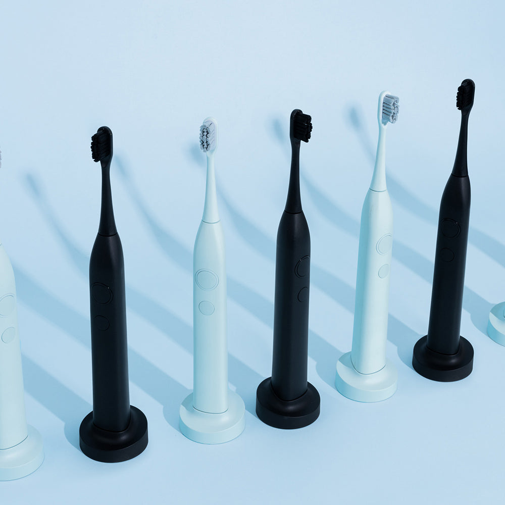 SmilePro Sonic-tandbørster i Soft Mint og Satin Black stående på række
